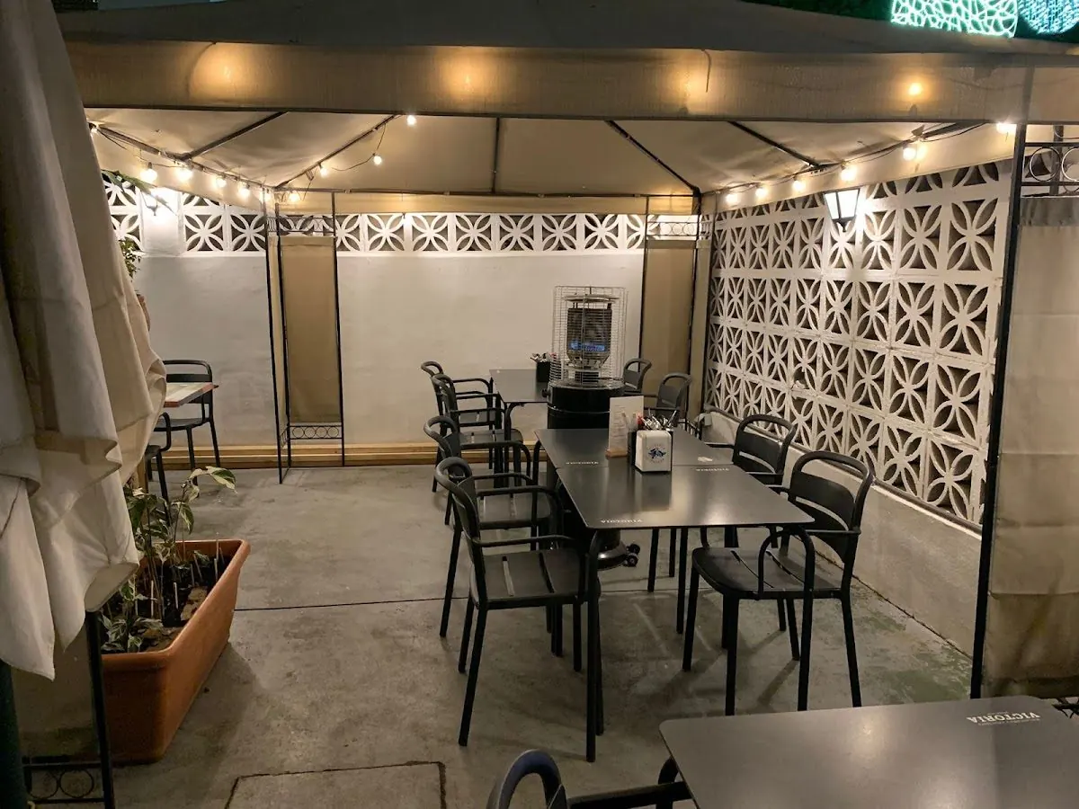 The patio at night: tent canopy, string lights, white lattice walls and black chairs / El patio de noche: carpa, luces, celosías blancas y sillas negras